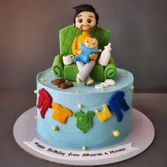 When it's the new dad's happy birthday. This vanilla and biscoff cake features a figurine of a dad relaxing on the couch with his baby, surrounded by baby clothes.