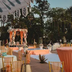 An elegant outdoor wedding setup. I designed this mandap with peach-colored drapes and florals, creating a soft and romantic atmosphere for a daytime ceremony.