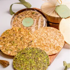 Enjoy the crunch of my Healthy Chikkis. This platter shows different varieties, including a vibrant green pistachio chikki, all made with natural jaggery and packed with flavour.