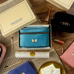 A luxurious flat lay of Faborange's velvet travel pouches. The items are styled as if being unboxed, surrounded by makeup brushes and other accessories to showcase their use as premium cosmetic or travel bags.