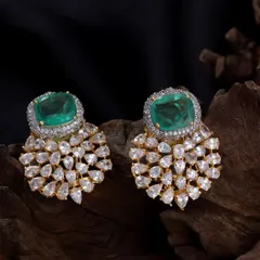 These statement studs are designed for maximum impact. They feature a large, rectangular emerald-colored stone surrounded by a halo of brilliant American Diamonds, with a cascade of smaller stones below.