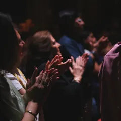 The audience in London, fully engaged and applauding during the show.