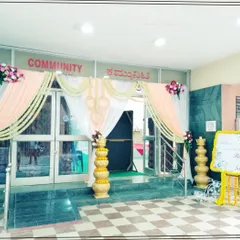 An elegant entrance decoration for a community hall, using soft peach and white drapes with floral accents. This design shows how even a simple space can be transformed into a graceful entry for a wedding or reception.