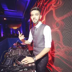 A shot of me DJing at a private event, dressed in a more formal waistcoat and tie. I adapt my style to suit the occasion while still bringing the party vibe.
