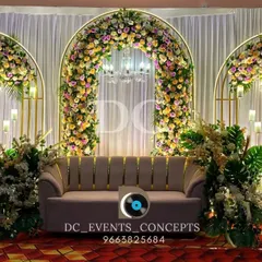 This elegant reception stage uses three floral arches with integrated chandeliers, creating a classic and symmetrical design that exudes timeless romance.