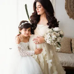 A precious moment between a mamma and her daughter. The coordinating white dresses are so angelic, and their bond is just beautiful to see.