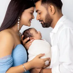 A beautiful family portrait with a newborn. The parents' loving gaze and gentle touch create a heartwarming image that celebrates their new arrival.