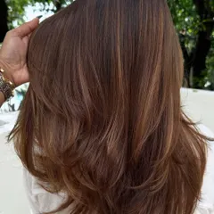 The back view of her color refresh. We added subtle highlights to her brunette hair for a natural, sun-kissed look.