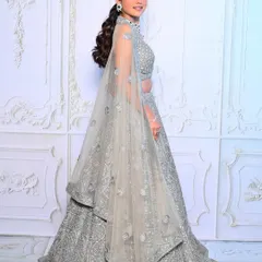 An elegant reception look in a silver-grey lehenga. The makeup features a cool-toned smokey eye and a chic ponytail, creating a sophisticated and modern bridal style.