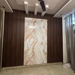 For this wall, I combined two distinct styles. The main wall is covered in dark wood-finish WPC panels, creating a sophisticated backdrop for the central, high-gloss UV marble sheet that acts as a piece of art.