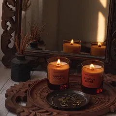 A moody and reflective shot of Mineral Project candles, using a vintage mirror and carved wooden tray to create a rich, traditional aesthetic.