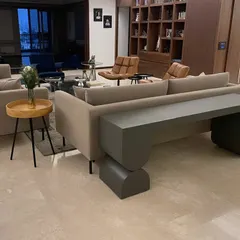 The grey console table in its final setting, providing a functional surface and a strong, modern design element in this spacious living room.