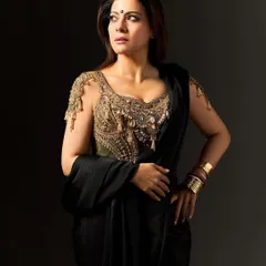 This shot showcases the stacked gold bangles and the loose, fluid drape of the black saree, designed to feel wild and free.