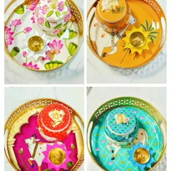 Our collection of Pichwai tray sets comes in various vibrant colors and designs. Each set includes a matching jar and a brass lotus diya, making it a complete and beautiful addition to your festive decor.