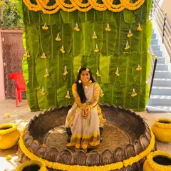 A complete Haldi ceremony setup designed to be both traditional and picture perfect. The backdrop is made entirely of fresh banana leaves, decorated with marigold garlands. We placed a large decorative urli in the center for the ceremony, surrounded by matching yellow pots to complete the vibrant, auspicious theme.