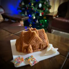 My decorate-your-own Christmas Cottage cake, sitting pretty by the tree. This kit is all about providing a fun, festive activity for the family without any of the stress.