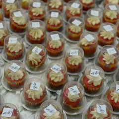 Hundreds of our mini red velvet cupcakes with cream cheese frosting, individually packaged and ready to be served as wedding favors. We ensure every detail is perfect for your big day.