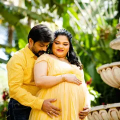 A classic pose for expecting couples, with both partners gently holding the baby bump. The warm sunlight and their close embrace create a feeling of love and protection.