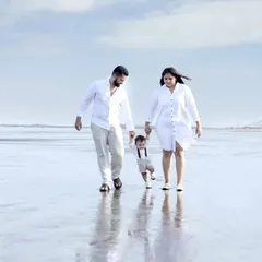 A candid shot of parents helping their toddler take his first steps on the wet sand. Our beach photography sessions are perfect for capturing these unscripted, milestone moments for your family.