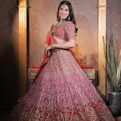 A full view of bridal splendour. This stunning red and pink ombre lehenga is paired with a soft glam makeup look, ensuring the bride herself remains the focal point.