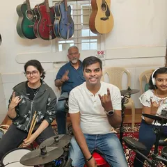 Say hello to our drum students! This photo captures the energy and joy of students of all ages learning to play the drums, an instrument that represents pure expression.