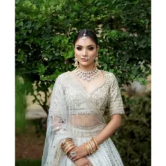 A classic portrait of a bride in an elegant white lehenga, showcasing her poise and beauty.