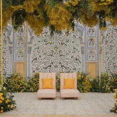 The Haldi ceremony seating set against a stunning hand-painted backdrop, framed by an abundance of yellow flowers.