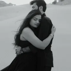 A powerful and intimate embrace in the Dubai desert. The black and white tones emphasize the texture of the sand and the deep connection between the couple.