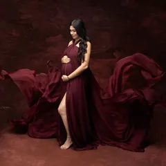 Pure magic in a single frame. This flowing maroon gown and artistic backdrop come together to tell a story of strength, beauty, and the powerful love of a mother.