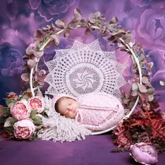 A dreamy purple-themed setup for a twin photoshoot, with one baby resting in a beautiful macrame swing. We design elaborate sets that can accommodate one or both babies.