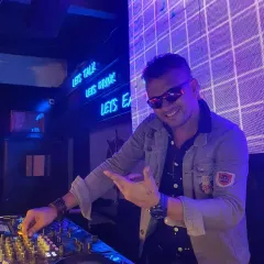 All smiles behind the console, pointing to the crowd. My focus is always on the people, making sure everyone is having a great time.