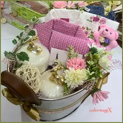 A luxurious baby girl hamper presented in a rustic-chic metal tub. The arrangement includes a pink tweed jacket, a soft teddy bear, and decorative golden deer figures, blending elegance with playful charm.