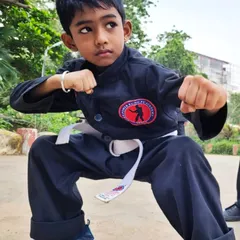 A young boy holds a perfect ready stance, his eyes showing incredible focus. Our kids' classes help develop this kind of concentration from an early age.