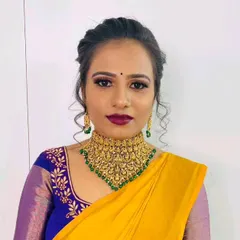 This temple jewellery choker features intricate carvings and green bead accents, perfect for pairing with a silk saree.