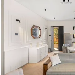 The living room of the Denkanikotta prefab home features elegant wall molding and a mix of modern and classic furniture. The design creates a sophisticated yet comfortable atmosphere.