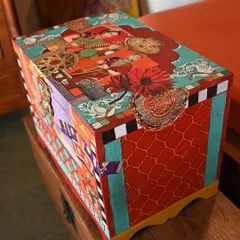 An angled view of the memory box, showing how the artwork wraps around the sides. The design layers colonial-era portraits with vibrant patterns, creating a piece that is rich in history and visual interest.