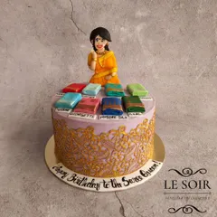 I love bringing your passions to life, like with this "Saree Queen" cake. It features a hand-sculpted figurine and a collection of miniature, detailed 3D sarees in various styles like Mysore Silk and Georgette, all sitting on a cake with an intricate golden lace design.