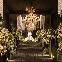 An elegant Sangeet entrance at Shiv Niwas Palace, featuring cascading crystal chandeliers and lush white florals. I design every corner to whisper luxury, creating a cohesive and opulent experience for your guests.