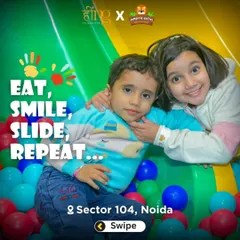 Siblings enjoying the ball pit together at the bottom of the slides. It's a great place for kids to play, interact, and make new friends.