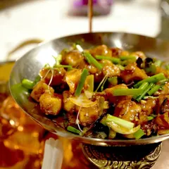 A serving of our Tangra-style chili chicken, a classic Indo-Chinese dish that is a staple on our menu. It's prepared with the authentic flavors of Kolkata's Chinatown and served in traditional metalware.