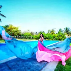 Create a splash with this unique dual-tone flying tail gown in shades of blue and pink. The lightweight fabric is designed to catch the wind, producing spectacular, colorful effects for a truly dynamic poolside or beach maternity shoot.