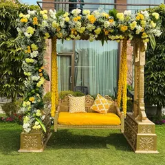 A classic Haldi jhoola (swing) decorated with a mix of yellow and white flowers. This provides a beautiful and traditional seating spot for the bride and groom during the ceremony.