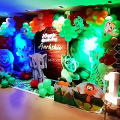 Another angle of the jungle safari party, showcasing the depth of the decoration with layered cutouts and a lush balloon garland in green, orange, and white.