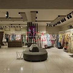 This wide shot of the Jubinav Chadha Fashion Design Studio in New Delhi captures the overall retail environment I created. The design, inspired by Indian temple carvings, features a central seating area, custom display racks, and strategic track lighting to create an immersive and high-end shopping experience.