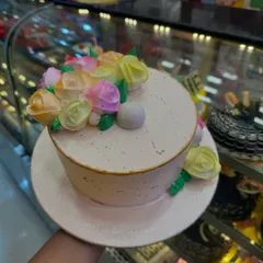A simple yet beautiful cake for someone who loves flowers. This design features a smooth, pale pink frosting adorned with a bouquet of hand-piped buttercream roses in pastel shades. It’s a delicate and artistic choice for any celebration.