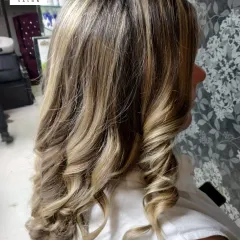 A side view of the golden blonde balayage, showing how the highlights are woven through the mid-lengths and ends for a radiant, sunlit effect.