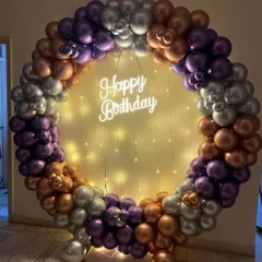 This chrome balloon ring uses a beautiful color palette of purple, silver, and copper. The addition of a "Happy Birthday" neon sign and delicate fairy lights in the center creates a warm and celebratory glow.
