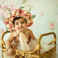 This adorable six-month-old is all smiles in her beautiful floral bonnet. Sitter sessions are perfect for capturing your baby's personality as they begin to explore the world around them.