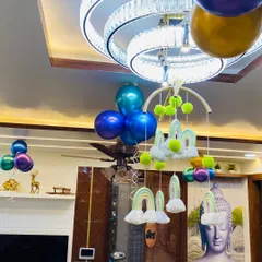 Simple yet festive ceiling decorations for a home party. This includes balloon bunches and a cute rainbow-themed hanging mobile.