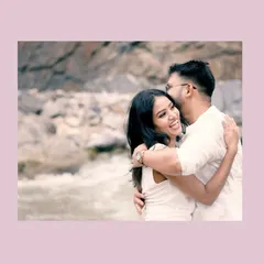 A candid, joyful moment as a couple hugs by the river, their laughter making for a perfect, natural shot.